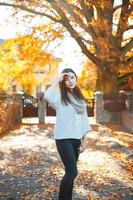 hermosa chica en un suéter sobre un fondo del parque de otoño foto