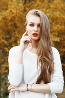 retrato de mujer hermosa con labios rojos sobre un fondo de flores amarillas floreciendo. tiempo de primavera foto