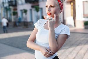 Beautiful stylish girl. Shopping centers and people in the background. photo