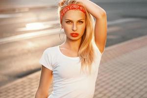 Portrait of a beautiful hipster with red lips at sunset. retro look photo