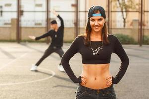 Portrait of a beautiful dancer girl on a background of the hip hop dancer. photo