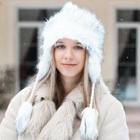 hermosa chica en la chaqueta de invierno de pie cerca de la casa foto