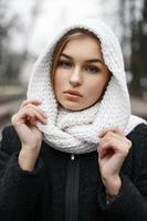 linda chica con estilo en una bufanda de punto blanco en el parque de otoño de fondo foto