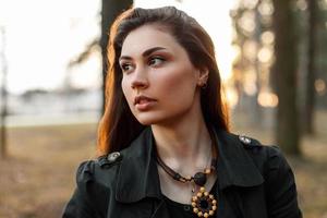 Beautiful sad girl with a tear in the park at sunset photo