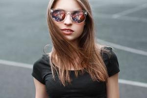 Beautiful girl in sunglasses. In the glasses reflection of space. photo