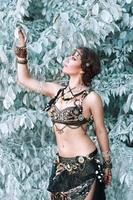 Pretty woman in tribal fusion costume near the beautiful white fairy tree. photo