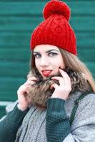 Young beautiful girl in retro style with a smile on a background of green wall photo