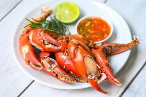 claw crab cooking food seafood plate with chili herbs spices lemon lime salad, fresh crab on white plate seafood sauce, boiled or steamed crab red in the restaurant photo