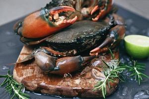 raw crab on wooden cutting board background , fresh mud crab with ice for cooking food in the seafood restaurant photo