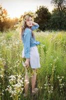 Beautiful girl  walking on field on summer with wildflowers. photo