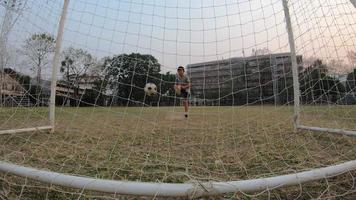 jongen speelt voetbal voetbal in groen veld - mensen met buitensport winnaar doel doel succes concept