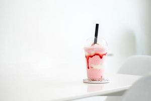 batido de fresa en la taza en la mesa blanca en la cafetería, concepto de comida, bebida y salud, espacio para copiar foto
