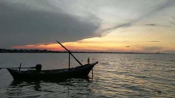 vista tramonto sul mare con una piccola barca di legno video