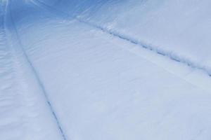 Abstract blue winter background. Tracks on snow. photo