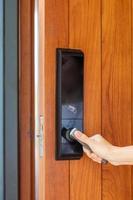 man holding handle of smart digital door lock while open or close the door. Technology, electrical and lifestyle concepts photo