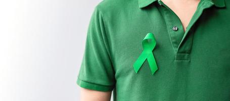 cinta verde para el mes de concientización sobre el hígado, las vesículas biliares, las vías biliares, el cuello uterino, el cáncer de riñón y el linfoma. concepto de salud y día mundial del cáncer foto