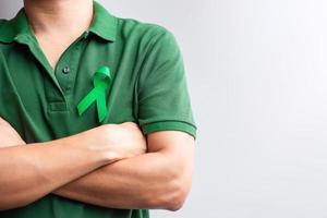 cinta verde para el mes de concientización sobre el hígado, las vesículas biliares, las vías biliares, el cuello uterino, el cáncer de riñón y el linfoma. concepto de salud y día mundial del cáncer foto