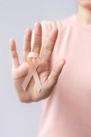 woman hand holding Peach Ribbon for September Uterine Cancer Awareness month. Healthcare and World cancer day concept photo