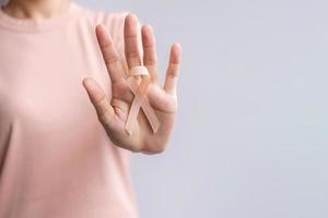 woman hand holding Peach Ribbon for September Uterine Cancer Awareness month. Healthcare and World cancer day concept photo