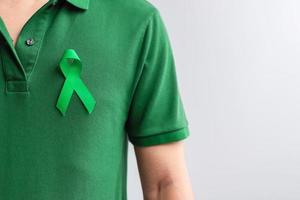 cinta verde para el mes de concientización sobre el hígado, las vesículas biliares, las vías biliares, el cuello uterino, el cáncer de riñón y el linfoma. concepto de salud y día mundial del cáncer foto