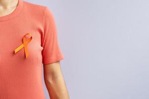 cinta naranja para la leucemia, día del cáncer de riñón, esclerosis múltiple mundial, crps, mes de concientización sobre las autolesiones. cuidado de la salud y el concepto del día del cáncer de palabra foto