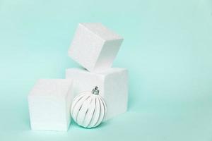 Simply minimal composition winter object ornament and cube shapes geometric form podium isolated blue pastel background. Christmas New Year december time for celebration concept. Mockup, copy space photo
