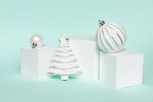 Simply minimal composition winter objects ornament and cube shapes geometric form podium isolated blue pastel background. Christmas New Year december time for celebration concept. Mockup, copy space photo
