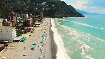 imagens aéreas do mar negro georgiano em sarpi mostrando a vista panorâmica do drone da bela praia rochosa com beira-mar turquesa. video