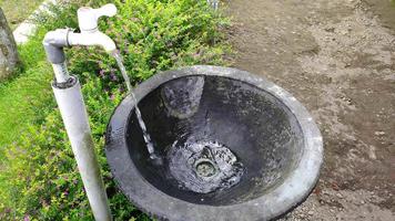 Wasser fließt aus einem Handwaschhahn aus Eruptivgestein