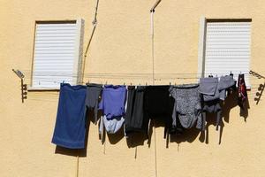 Washed linen dries on the street outside the window of the house. photo