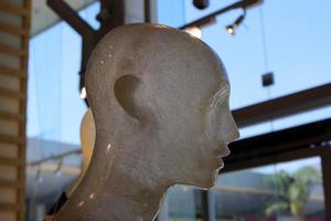 A mannequin stands on a showcase in a large store. photo