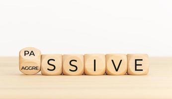 Passive Aggressive concept. Turning wooden block with word. Copy space photo