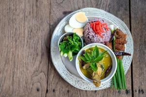 Green curry with rice vintage thai food on wooden table photo