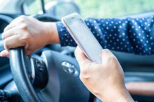 Bangkok, Thailand, July 1, 2021 Holding iPhone in toyota sienta car to communication with family and friends. photo