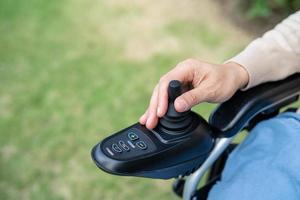 Asian lady woman patient on electric wheelchair with joystick and remote control at nursing hospital ward, healthy strong medical concept photo