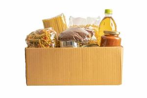 alimentos para donación, almacenamiento y entrega. varios alimentos, pasta, aceite de cocina y comida enlatada en caja aislada sobre fondo blanco con camino de recorte. foto