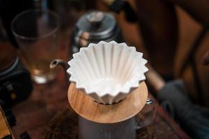 Drip coffee, barista pouring water on coffee ground with filter photo