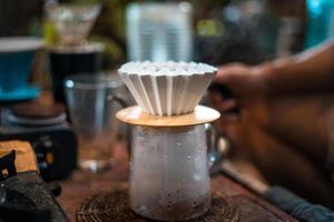 Drip coffee, barista pouring water on coffee ground with filter photo