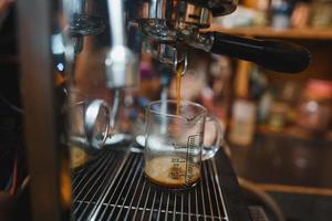 Expresso coffee dripping from the machine photo