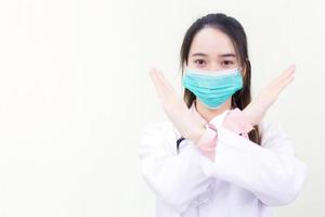 Asian woman doctor wears medical face mask while shows hand in stop photo