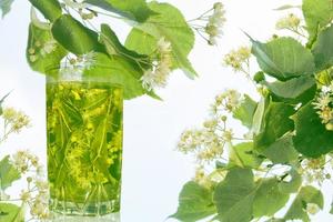 Lime glass of hot tea. Floral background. photo