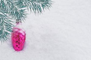 tarjeta de Navidad. rama de pino y juguetes sobre un fondo de nieve blanca. foto