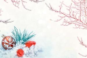 Christmas card. Pine branch and toys on a background of white snow. photo