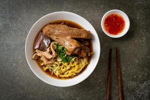 egg noodles with stewed and braised duck in brown soup photo