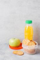 Crackers and fresh Apple and orange juice on the grey table. Copy space. Concept school Breakfast. photo