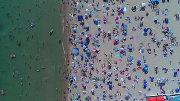 Vista mare ad alto angolo di fronte alla spiaggia con persone a Bournemouth, città dell'Inghilterra, Regno Unito, riprese aeree dell'Oceano Britannico video