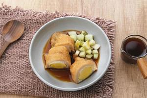 Pempek, Empek-Empek, traditional food from South Sumatra, Indonesia. This fish-based food is very popular. Served with cuko sauce and cucumber slices. photo