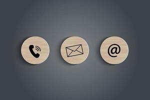 la dirección de correo electrónico, el número de teléfono y los iconos de letras imprimen la pantalla en un bloque de madera circular en la mesa para el contacto comercial de la página web y el concepto de servicio al cliente. ilustrador vectorial