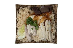 Above view of Hainanese chicken glutinous rice mix with Fried Chicken. Served in a coconut-patterned dish. Isolate white background with clipping path. photo