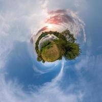 Little tiny planet. Spherical aerial 360 view panorama on the shore of small lake in sunny summer evening with awesome clouds photo